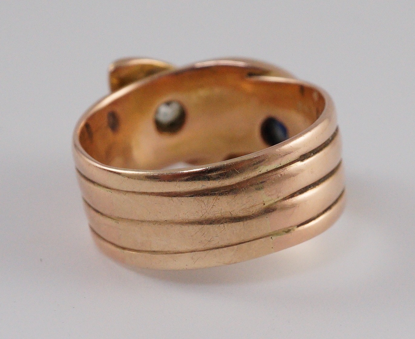A gold, cabochon sapphire and yellow diamond set twin serpent head ring
